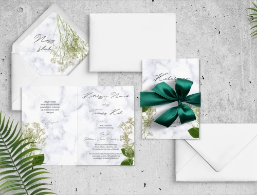 Piękne zaproszenie z gipsówką i motywem marmuru z białą kopertą i zieloną wstążką
