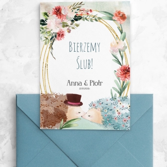 Zaproszenie z&nbsp;jeżykami i&nbsp;kwiatami drukowane na papierze satynowym z&nbsp;niebieską kopertą